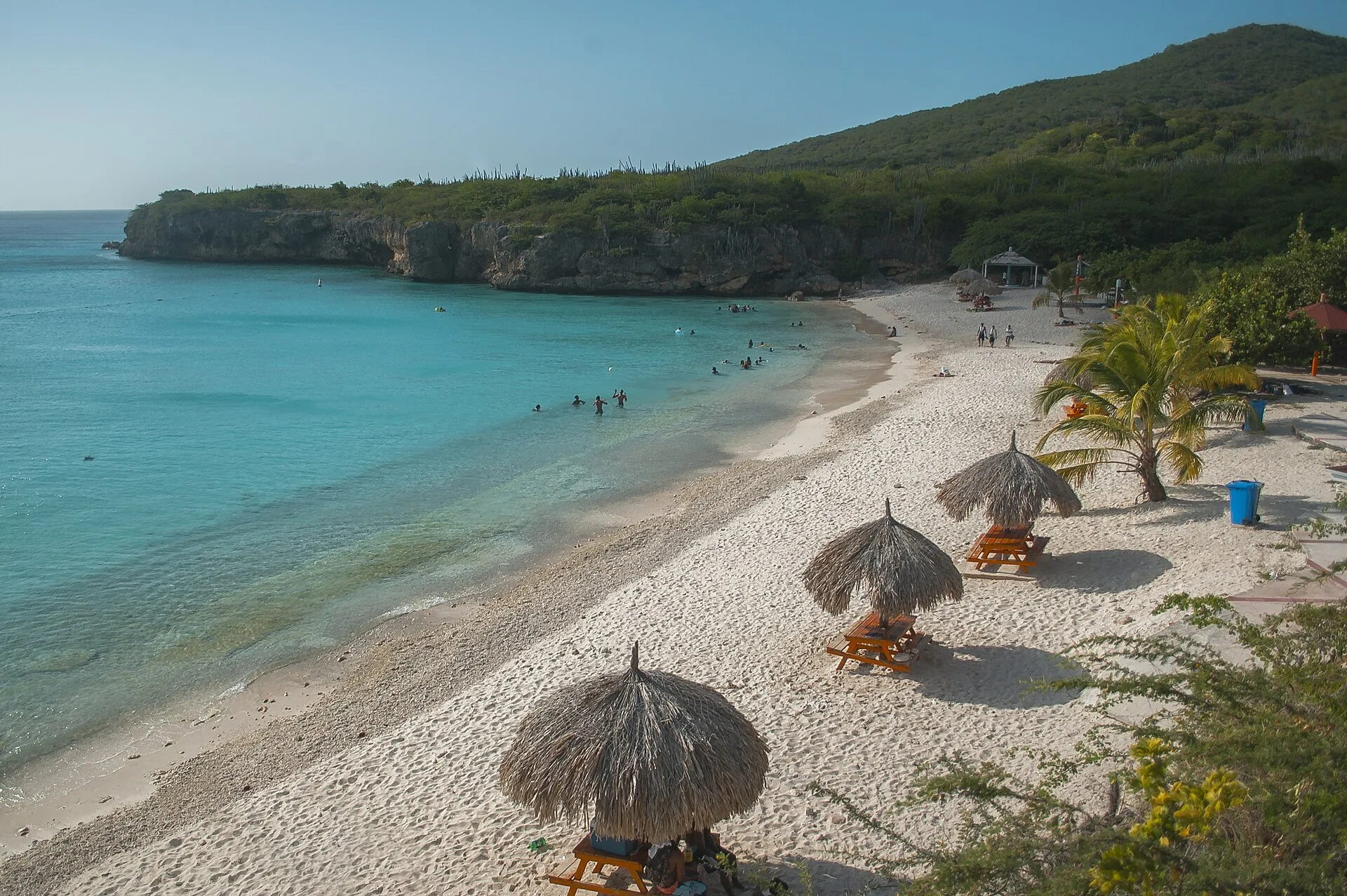 Turquoise baai van Grote Knip op Curaçao met witte zandstrook en groene heuvels op de achtergrond